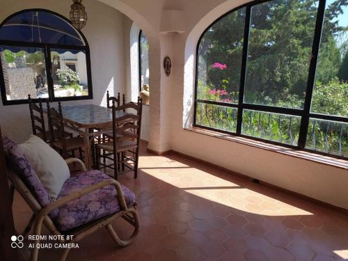 ベニッサにあるCasa Rustica Especialのテーブルと椅子、窓が備わる客室です。
