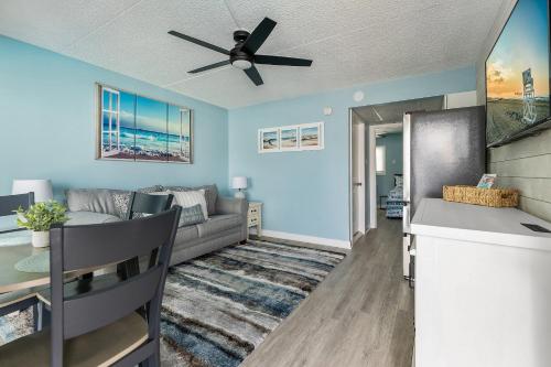 Harbor Light Family Resort في شمال وايلدوود: غرفة معيشة مع أريكة ومروحة سقف