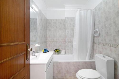 La salle de bains est pourvue de toilettes, d'un lavabo et d'une baignoire. dans l'établissement Apartamento Jade by Sunnyway, à Albufeira