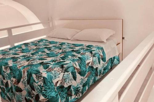 uma cama com um edredão verde e branco e almofadas em Casa Vacanze Aversa centro em Aversa