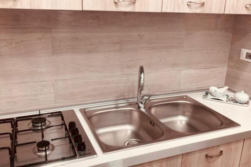 uma cozinha com um lavatório e um fogão em Casa Vacanze Aversa centro em Aversa