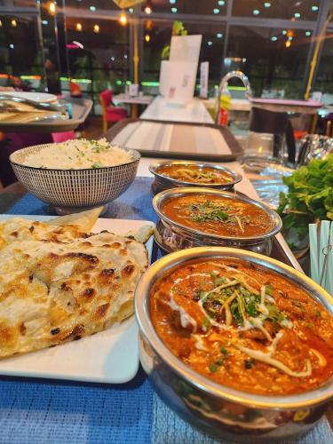 a table topped with bowls of food and pizza at Central Hotel Tana in Antananarivo