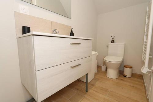 La salle de bains est pourvue d'une commode blanche et de toilettes. dans l'établissement Maison Charme & Mer à Dunkerque, à Dunkerque