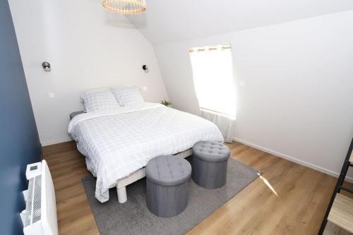 a white bedroom with a bed and two stools at Maison Charme & Mer à Dunkerque in Dunkerque