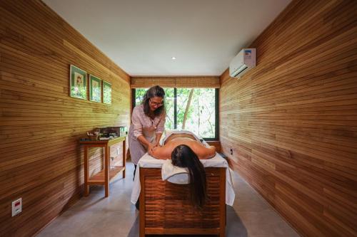 Eine Frau macht eine Massage in einem Zimmer in der Unterkunft Spa Posse do Corpo in Petrópolis