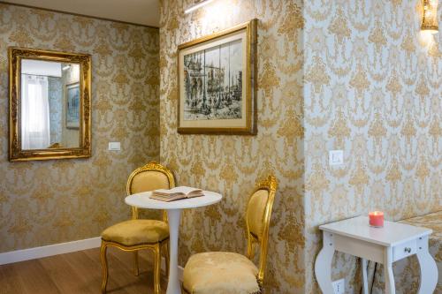 a table and chairs in a room with wallpaper at Hotel Apostoli Garden in Venice
