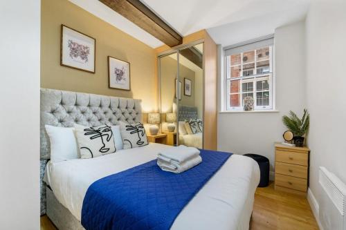 a bedroom with a large bed with a blue blanket at Host & Stay - Queen Square Apartment in Liverpool