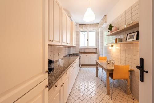 a kitchen with white cabinets and a table at Labiena Lake Maggiore in Laveno