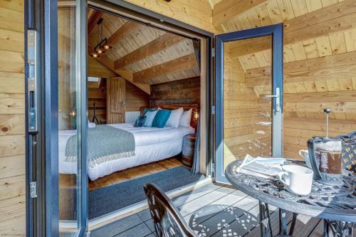a bedroom with a bed and a table on a balcony at Buttercup Lodge in Benson