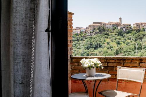 a table with a vase of flowers on a balcony at Locanda Le Tre Sorelle in Casal Velino