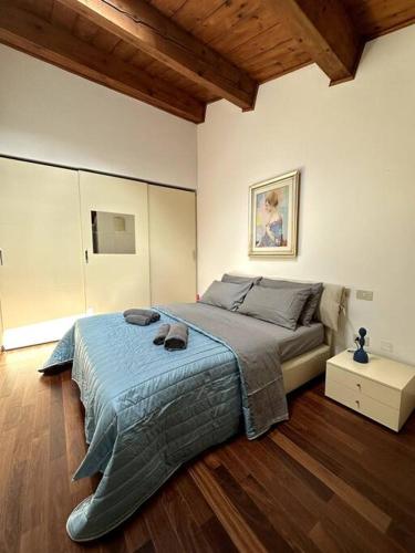 una camera da letto con un grande letto con una coperta blu di Casa Petrucci centro storico a Forlì