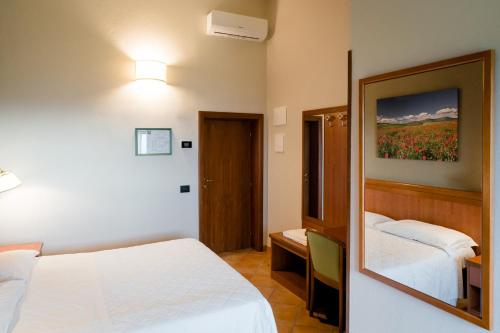 Кровать или кровати в номере Hotel La Scottiglia e Ristorante