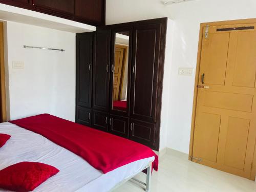 a bedroom with a bed with a dresser and a mirror at Rose Garden home stay Thrissur in Trichūr