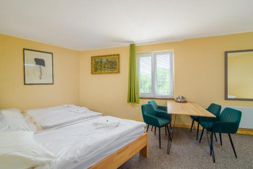 sypialnia z łóżkiem, stołem i krzesłami w obiekcie Hotel Max w Pradze