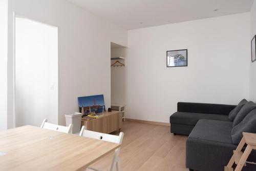 a living room with a couch and a table at Very bright nest close to Belleville park in Paris