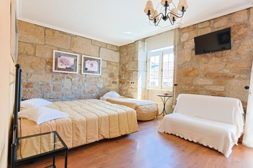 a bedroom with two beds and a stone wall at Residencial Bem Estar in Chaves