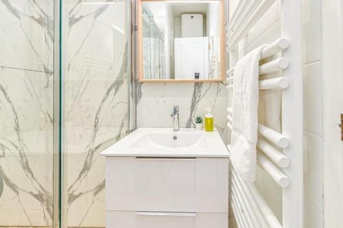 une salle de bain blanche avec un lavabo et une douche dans l'établissement Joli appartement - wifi - Vallier Catane, à Grenoble