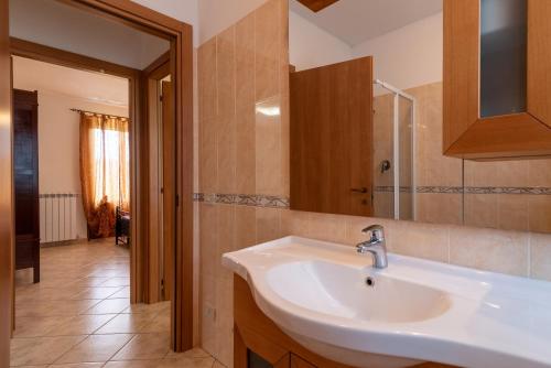 bagno con lavandino bianco e specchio di Casa Galina a Civitella in Val di Chiana