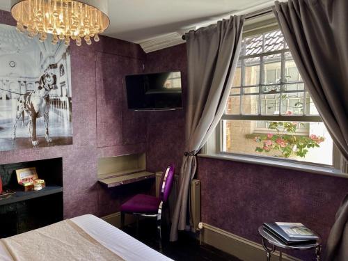 a bedroom with purple walls and a window and a bed at the kingsbury 7even 8ight in Marlborough