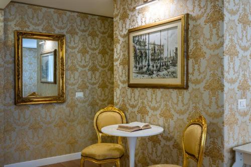 a room with two chairs and a table and two mirrors at Hotel Apostoli Garden in Venice