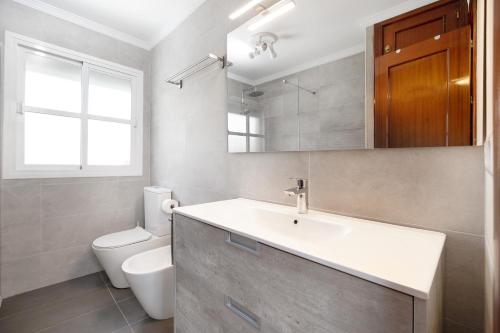 a bathroom with a sink and a toilet at Virgen del Camino 1a línea de playa in Chiclana de la Frontera