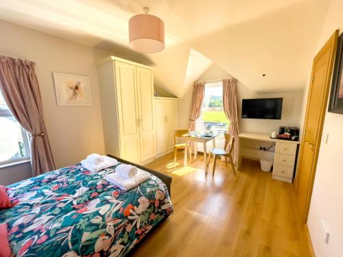 a bedroom with a bed and a desk and a table at Mount Edwards Hill Guest Accommodation in Cushendall