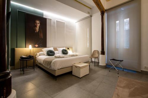 Les Monges Palace Boutique في أليكانتي: غرفة نوم بسرير مع لوحة على الحائط