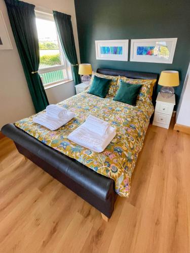 a bedroom with a bed with two towels on it at Mount Edwards Hill Guest Accommodation in Cushendall