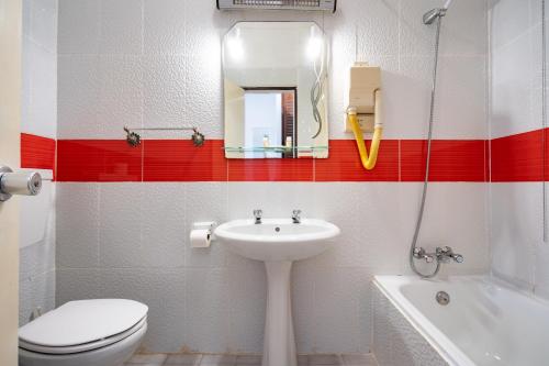 a bathroom with a sink and a toilet and a mirror at Quinta das Varandas by Umbral in Vila Nova de Milfontes