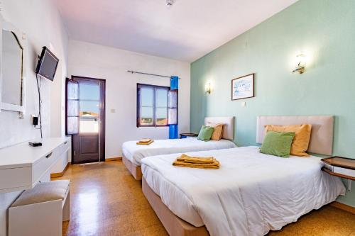 Duas camas num quarto com paredes azuis em Quinta das Varandas by Umbral em Vila Nova de Milfontes