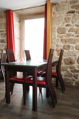 a dining room table with chairs and a stone wall at Alojamento Central in Chaves