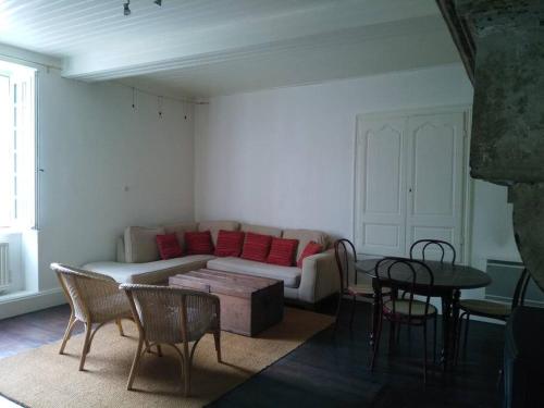 salon z kanapą, stołem i krzesłami w obiekcie Ecogîte La Charmette avec terrasse et jardin w mieście Suzannecourt