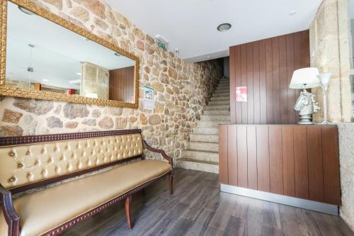 a waiting room with a bench and a mirror at Alojamento Central in Chaves