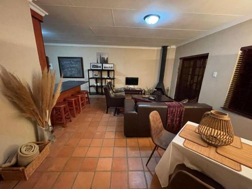 a living room with a couch and a table at DullVino Apartment @ Millers Cove in Dullstroom