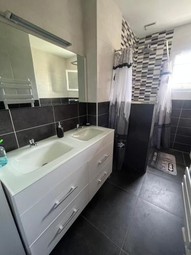 y baño con lavabo blanco y espejo. en Chambres d'Hôtes chez Estelle, en Crêches-sur-Saône