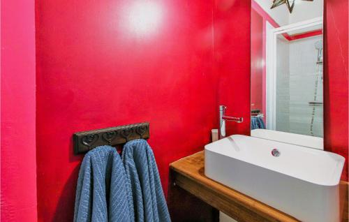 a bathroom with a white sink and a red wall at Beautiful Home In Die in Die