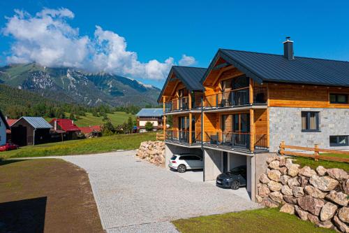 a wooden house with a car parked in front of it at Chalets Belianky - WELLNESS in Ždiar