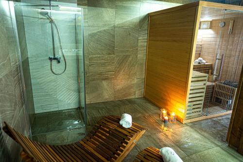 a shower stall with a bench in a bathroom at Chalets Belianky - WELLNESS in Ždiar
