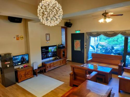 una sala de estar con muebles de madera y una lámpara de araña. en 好心情會館, en Hengchun