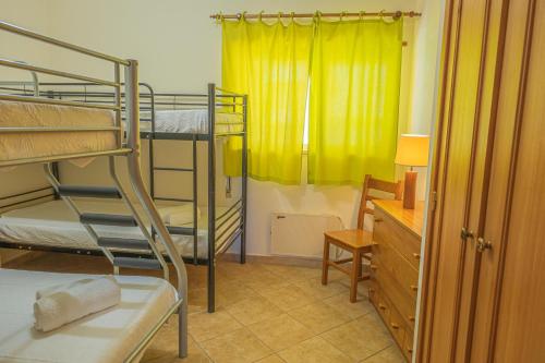 Cette chambre comprend 2 lits superposés et un rideau jaune. dans l'établissement Quinta da Amoreira by the Pool one, à Alvor