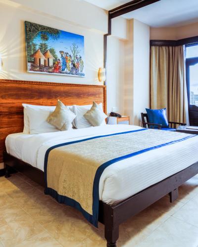 a bedroom with a large bed in a room at Hotel Sapphire in Mombasa