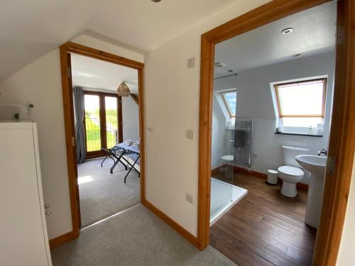 a bathroom with a tub and a toilet and a sink at Hay Loft in Bideford