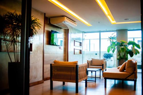 a lobby with couches and chairs in a building at Paradiso Macae Hotel in Macaé