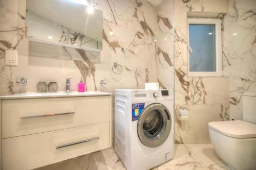 uma casa de banho branca com uma máquina de lavar roupa em Large & beautifully furnished 2 bedrooms ABON1-1 em Sliema