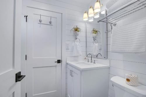 a white bathroom with a sink and a mirror at Coachman Cottage in Wimberley