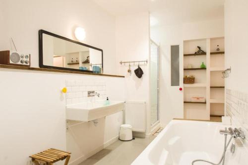 une salle de bain blanche avec une baignoire et un lavabo dans l'établissement La maison du Merle: le charme en centre-ville, à Toulouse