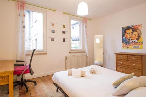 - une chambre avec 2 lits, un bureau et une fenêtre dans l'établissement La maison du Merle: le charme en centre-ville, à Toulouse