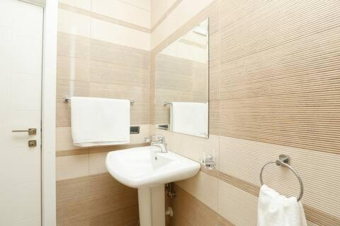 a bathroom with a sink and a mirror at Miku Apartment -Outstanding Apartment at Taiwan in Tirana