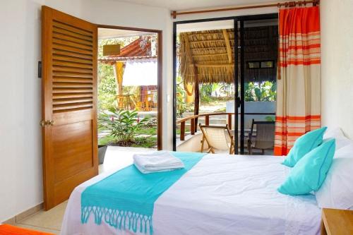 - une chambre avec un grand lit et un balcon dans l'établissement Casa Yoo Bigu Mazunte, à Mazunte