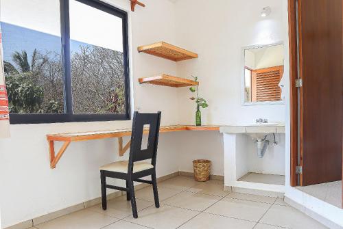a bathroom with a chair and a sink and a window at Casa Yoo Bigu Mazunte in Mazunte
